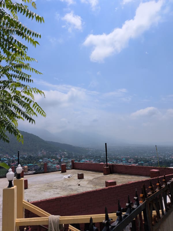 Abandoned hillside structure and city views in Dharamshala