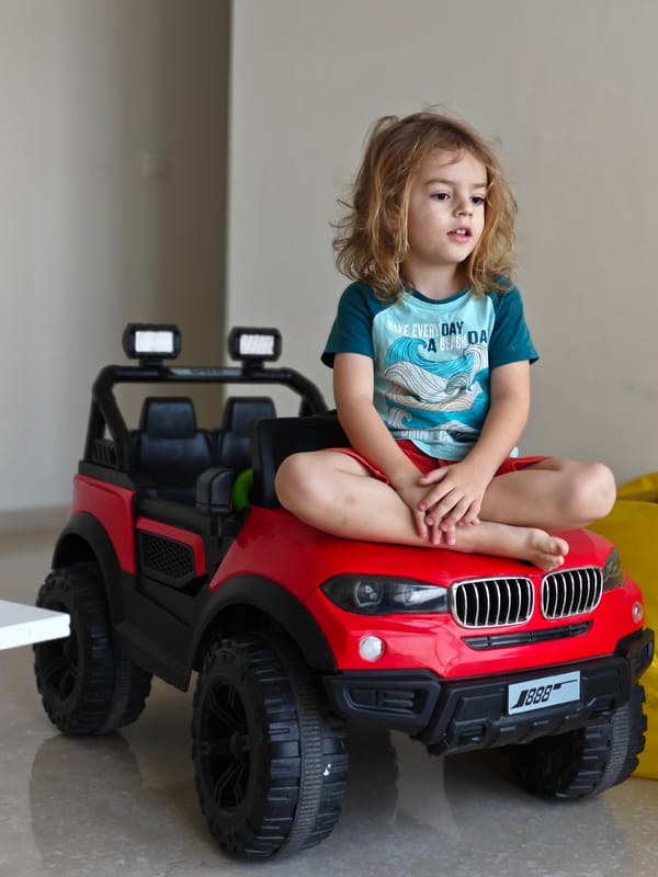 Child plays with red toy car in Mumbai
