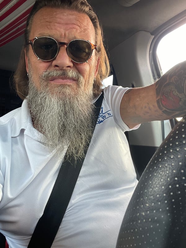Tattooed driver in sunglasses, buckled up in Netanya