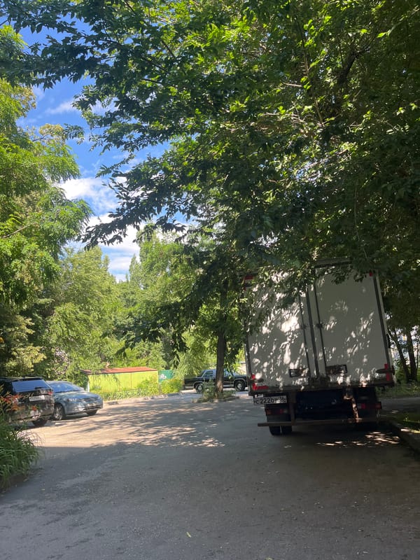 White box truck parked under green canopy in Voronezh