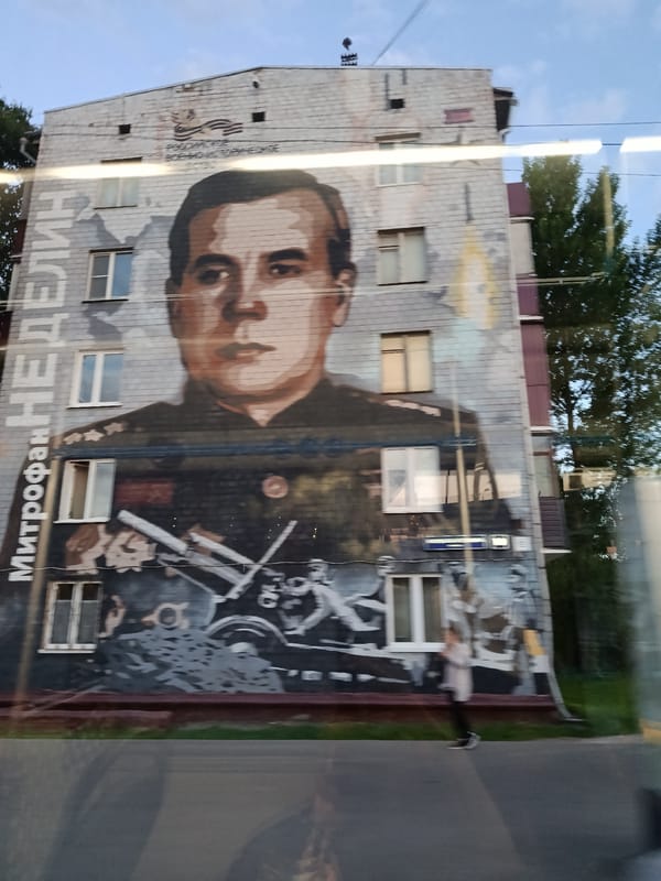 Moscow street scenes include military mural, decorated truck