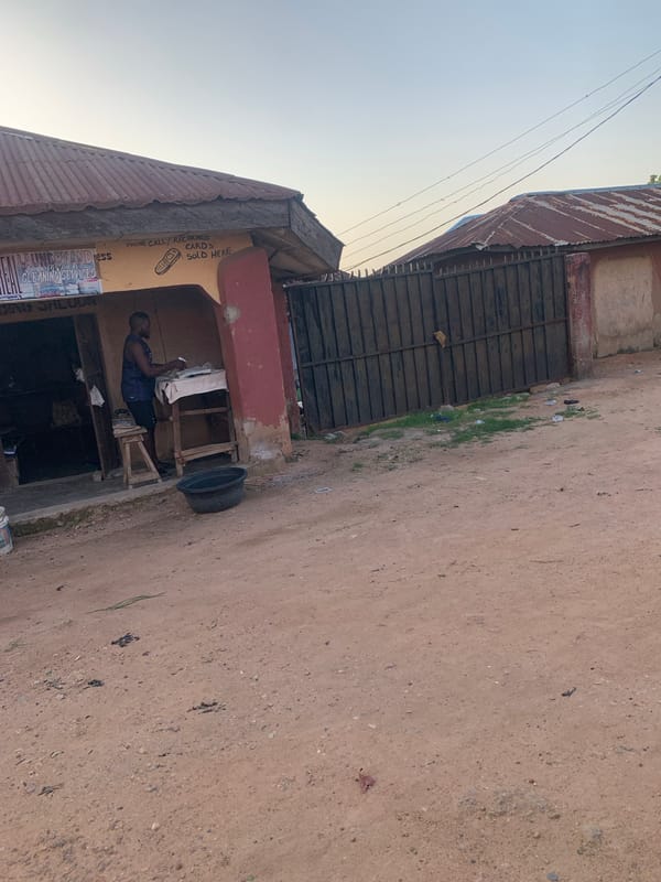 Jalingo street market: clothing stalls, rusted sheds, and afternoon light