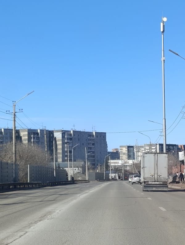 Clear day street scene in Krasnoyarsk with apartments tower