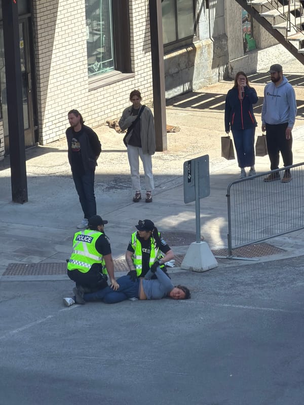 Police officers attend to person on Montreal sidewalk