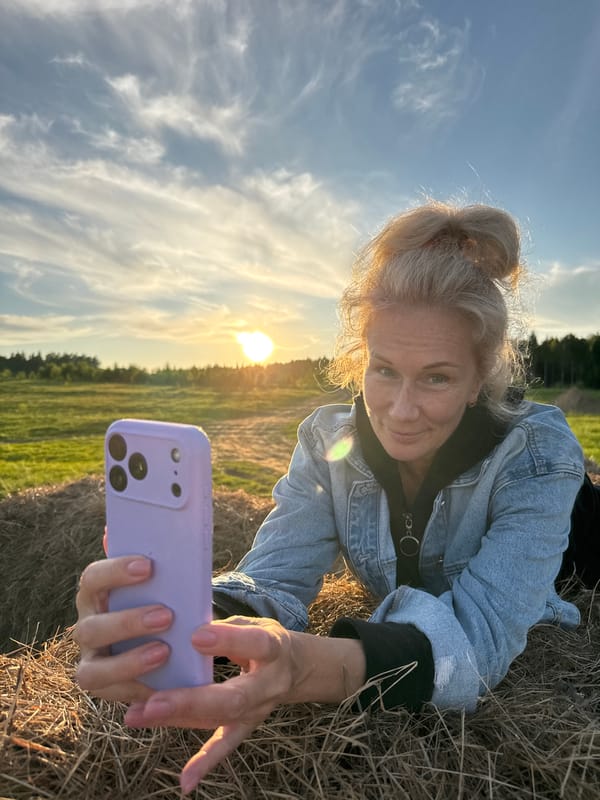 Woman poses on hay bales during sunset in rural Russia