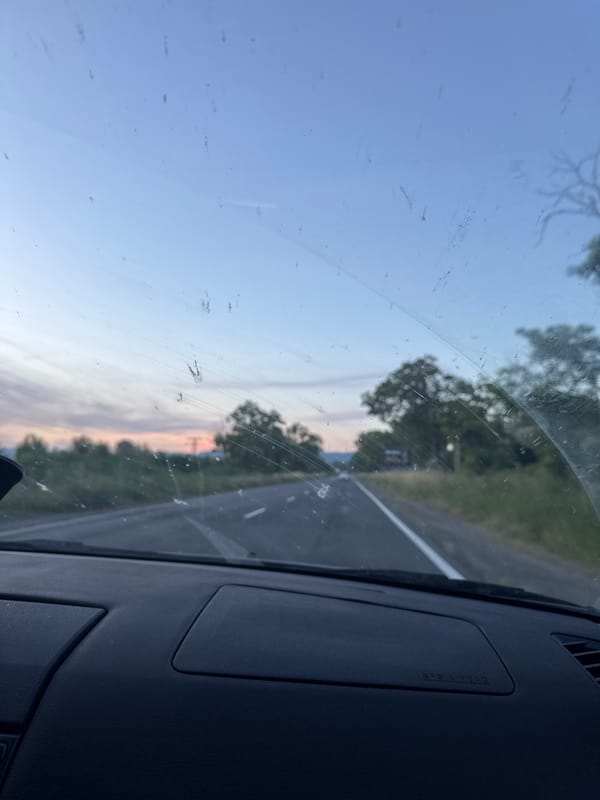 Two women travel on two-lane road in moving vehicle