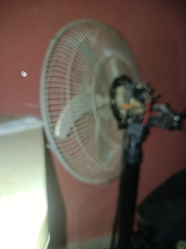 Indoor scene with rotating fan and person documented
