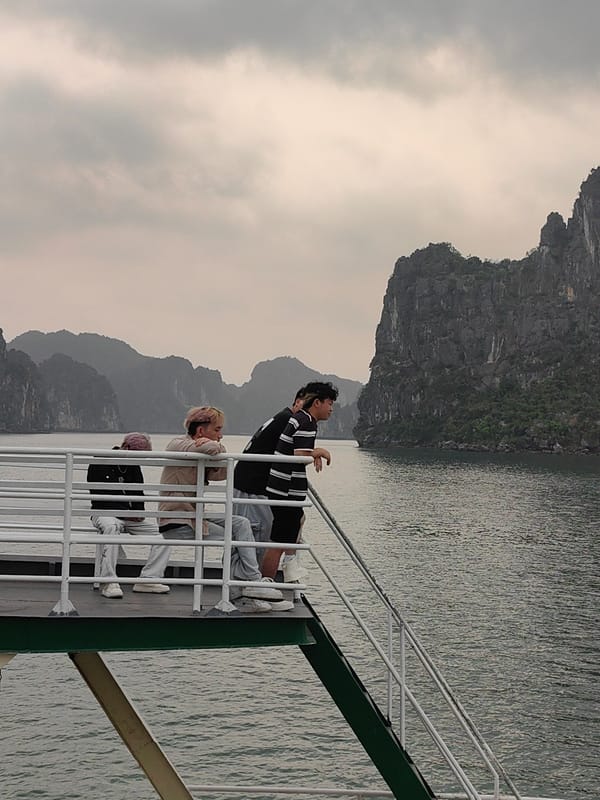 Young travelers observe landscape from boat deck in Vietnam