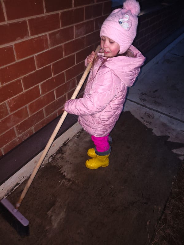 Child with broom spotted in pink winter outfit in Chaikovsky