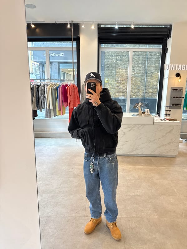 Person takes mirror selfies at London vintage clothing store