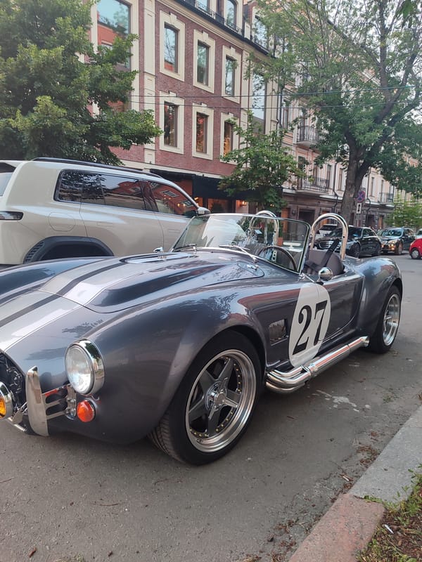 Shelby Cobra replica #27 parked streetside at dusk