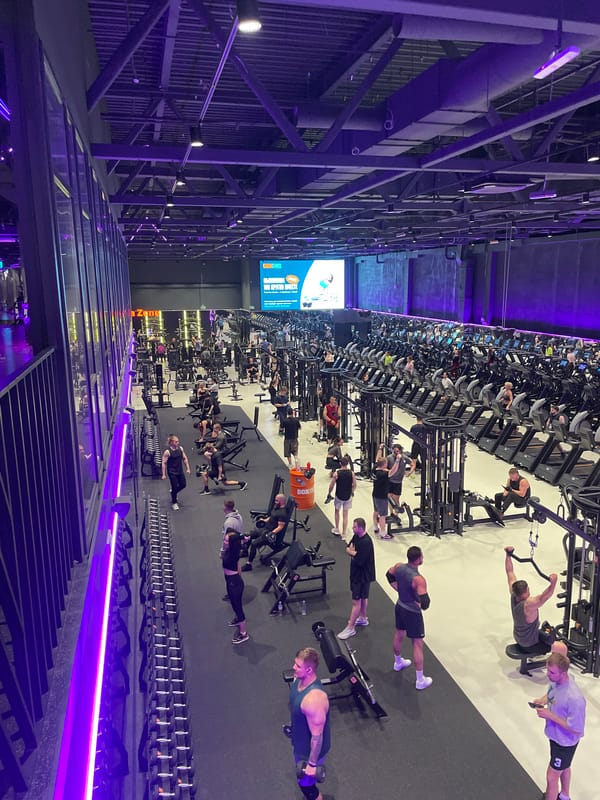 Active evening session inside a sleek, purple-lit gym