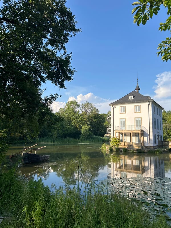 Historic white manor reflects in still water, Heilbronn
