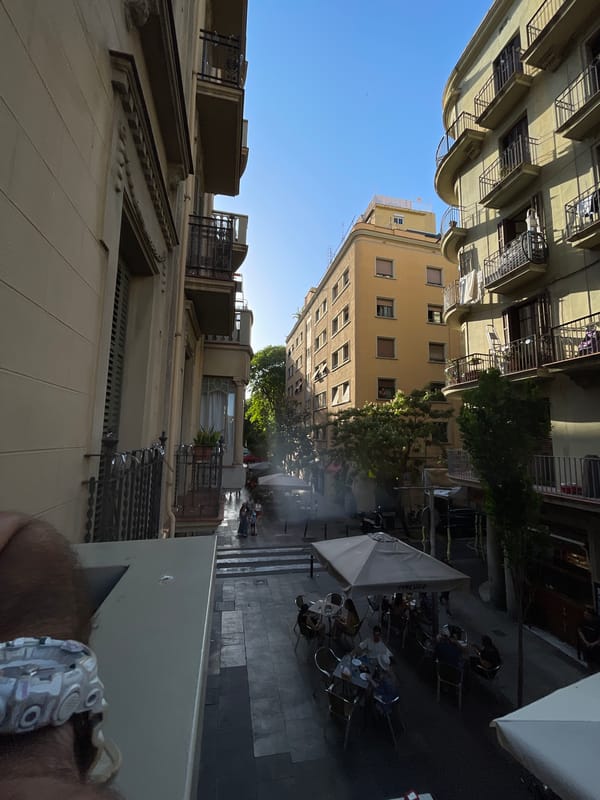 Barcelona balcony afternoon: narrow streets, cafes, clear skies