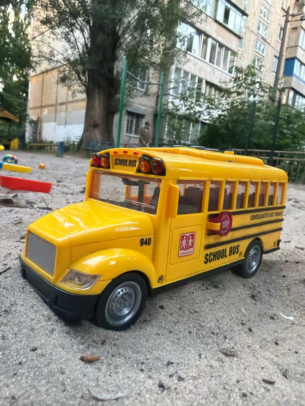 Toy vehicles lined up on a sandy Kyiv playground
