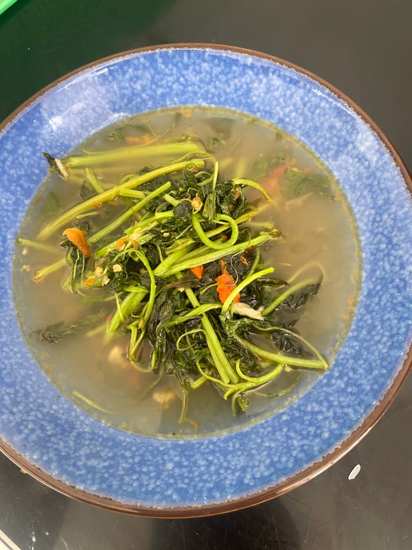 Water spinach soup in progress, with ants on the wall