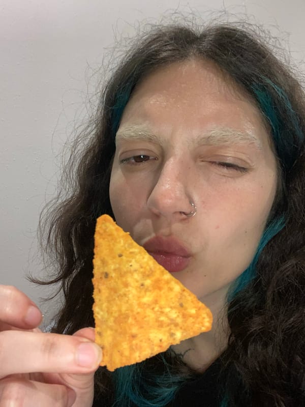 Person playfully poses with tortilla chip in Gijón
