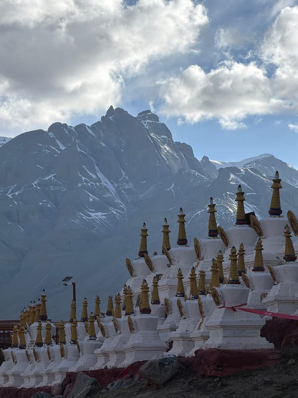 Snow-capped mountains observed near golden-spired building in Parga, China
