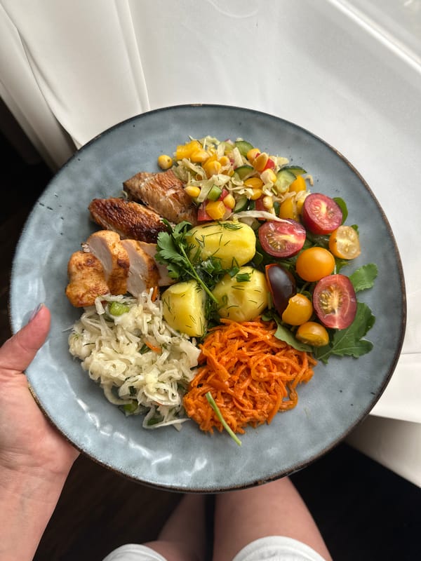 Person holds colorful meal on ceramic plate in Chaikovsky