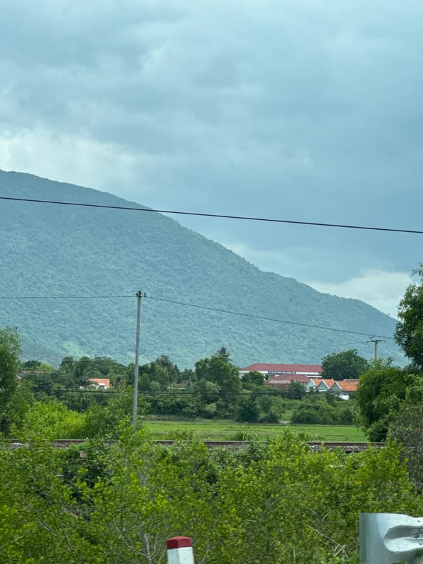 Lush green mountainside under cloudy skies in Ninh Hòa