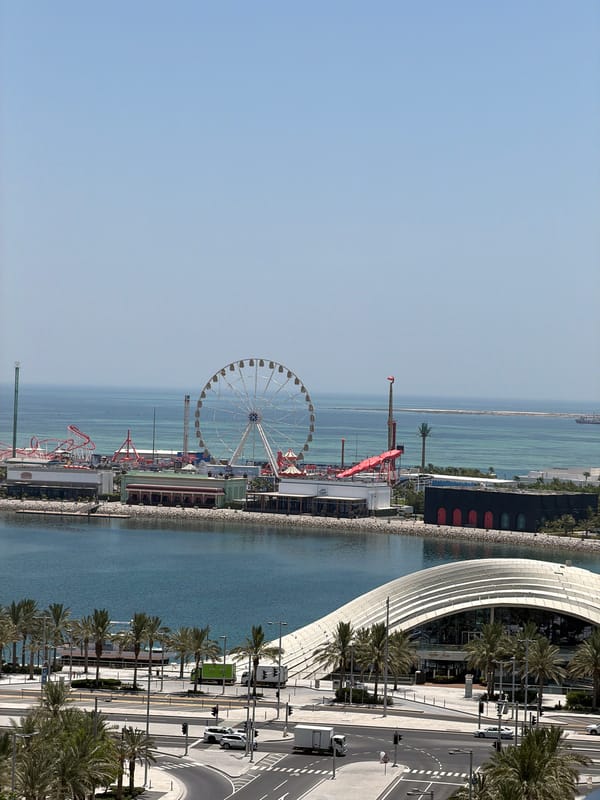 Balcony view over a coastal city with a waterfront amusement park