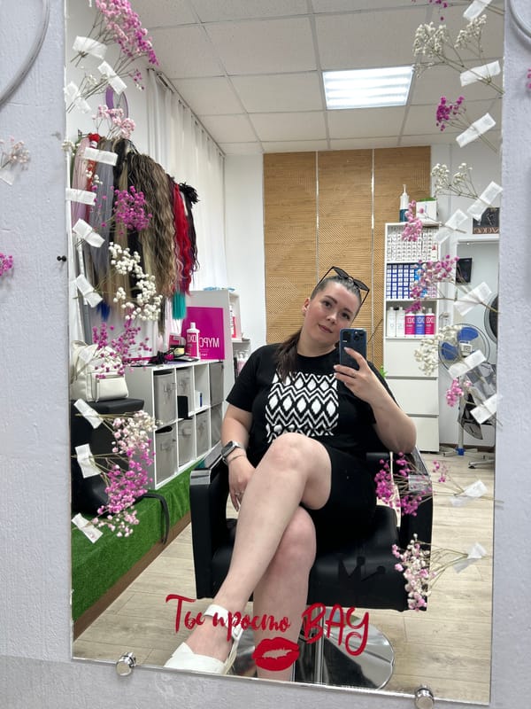 Woman takes selfie in flower-decorated salon mirror