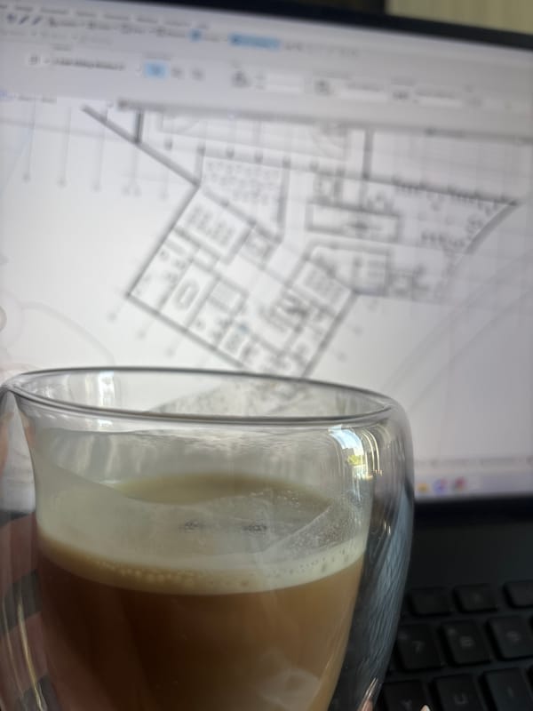 Morning coffee and architectural blueprints captured in Yerevan workspace