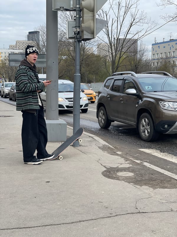 Young person observed on urban sidewalk during overcast afternoon