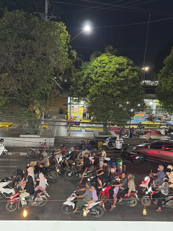 Batang intersection at night, motorbikes and a cycling LED sign