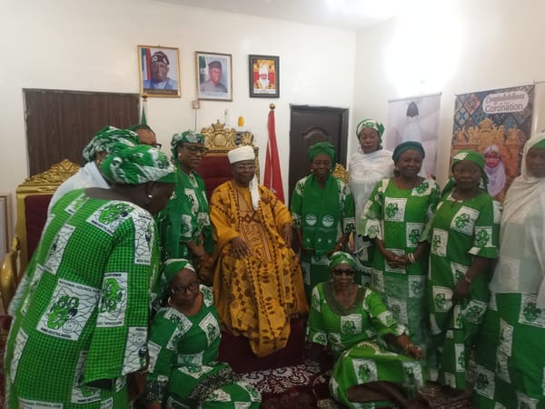 Formal group photograph with robed leader on golden throne