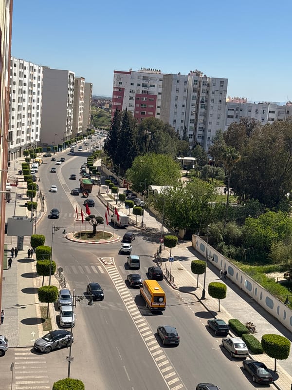 Traffic flows through Meknes roundabout with maintenance vehicle present