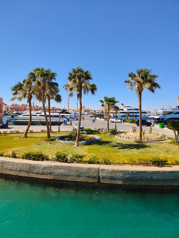 Hurghada marina on a sunny afternoon, yachts docked and calm.