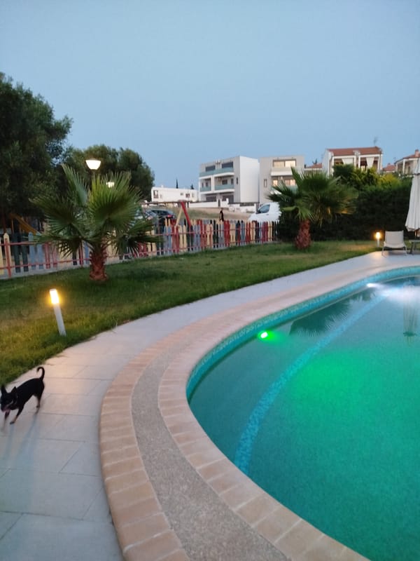 Sithonia resort grounds at dusk, pools lit and grounds quiet