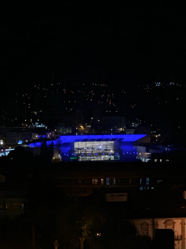 Blue-lit modern structure illuminates Vila Real Portugal nightscape