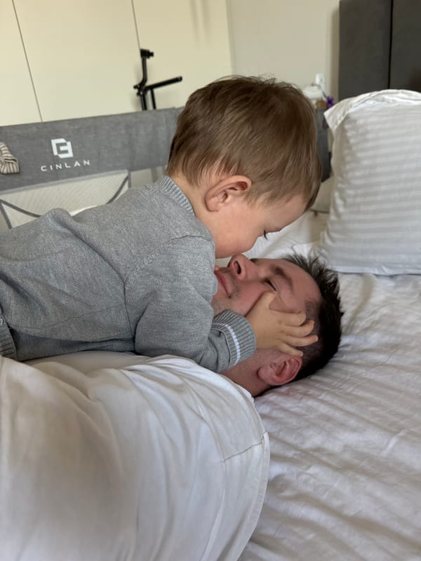 Father and toddler share quiet moment on bed in Odintsovo