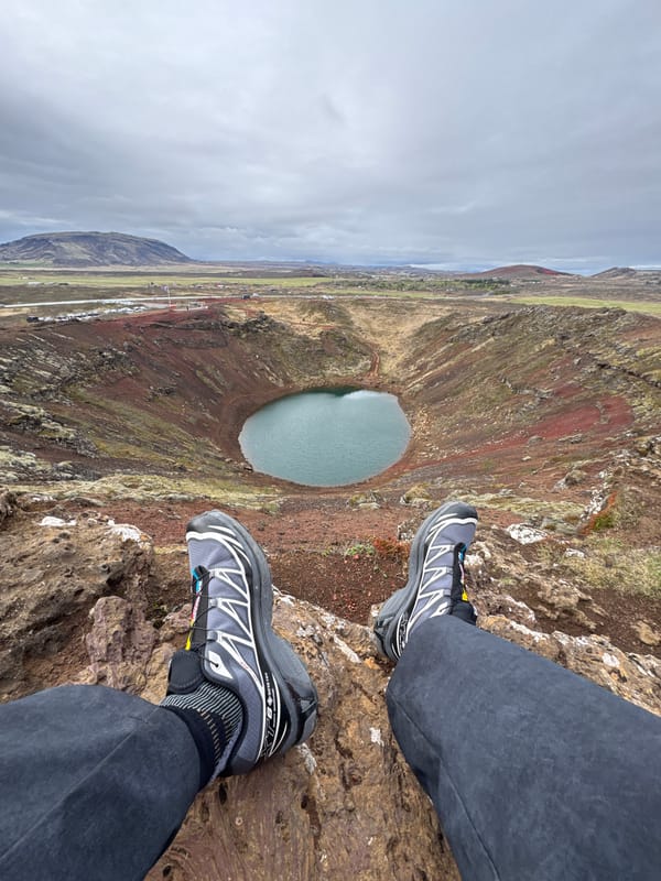 Tourist sits at edge of Iceland's Kerid volcanic crater