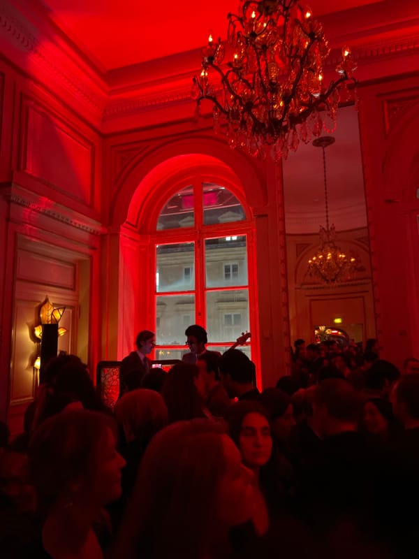 Red-lit evening event in ornate Parisian venue