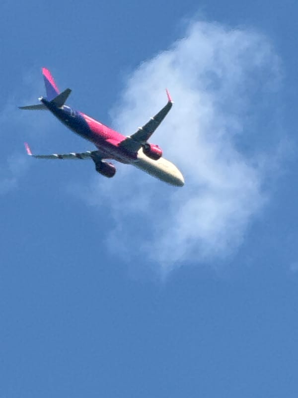 Crowded summer beach day in Varna with a passing aircraft