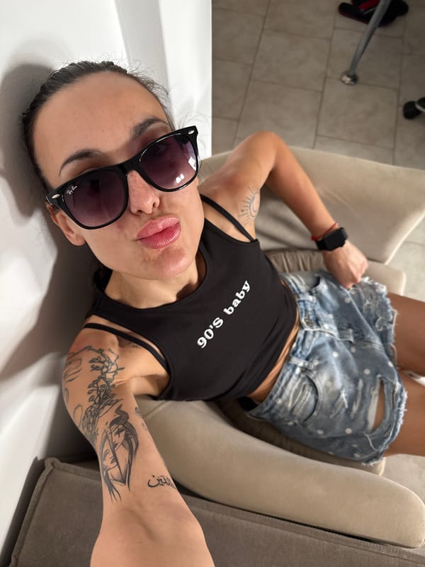 Woman relaxes in chair wearing 90s tank top in Chania