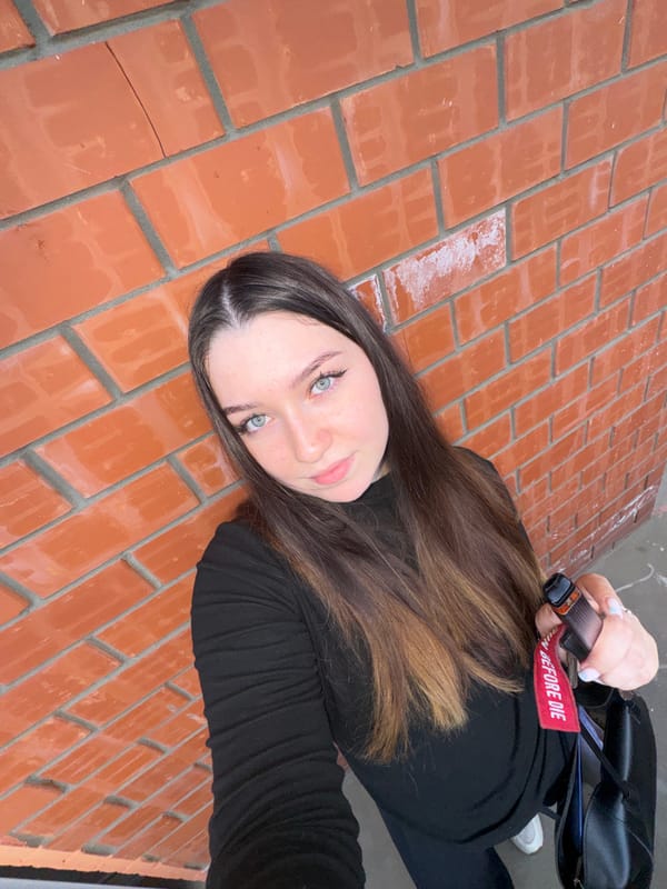 Woman takes selfies against brick wall in Perm, Russia