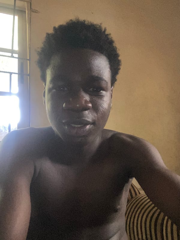 Man rests on cushion with toy in Mararaba home