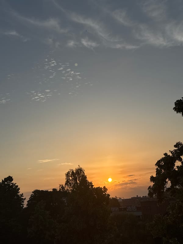 Summer solstice sunrise over Lübeck streets and sky