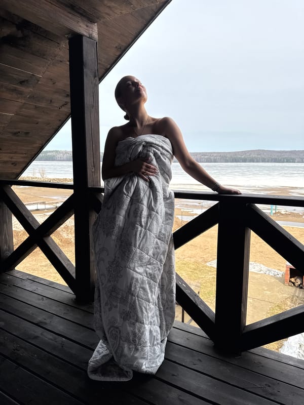 Woman in white blanket observed on balcony in Chaikovsky