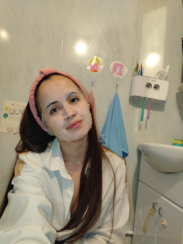 Woman applies face mask in bathroom during morning routine