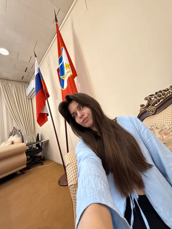 Woman takes selfies in formal diplomatic office with flags