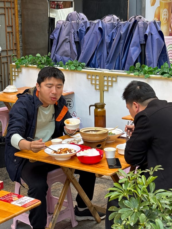 Two men share meal at table in Jinjiang District