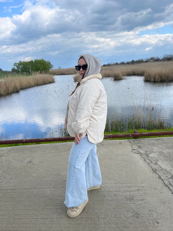 Woman spotted near waterfront amid spring blooms in Novopokrovskaya