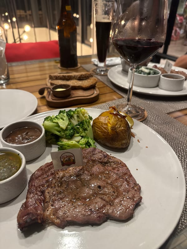 Restaurant dinner documented with steak, sides, and wine