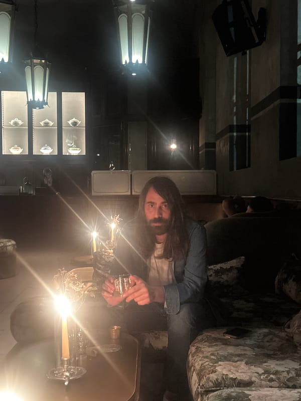 Man enjoys drink at illuminated Milan bar