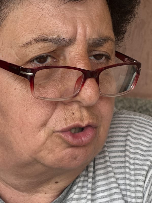 Elderly woman with red glasses uses smartphone in Bulgaria
